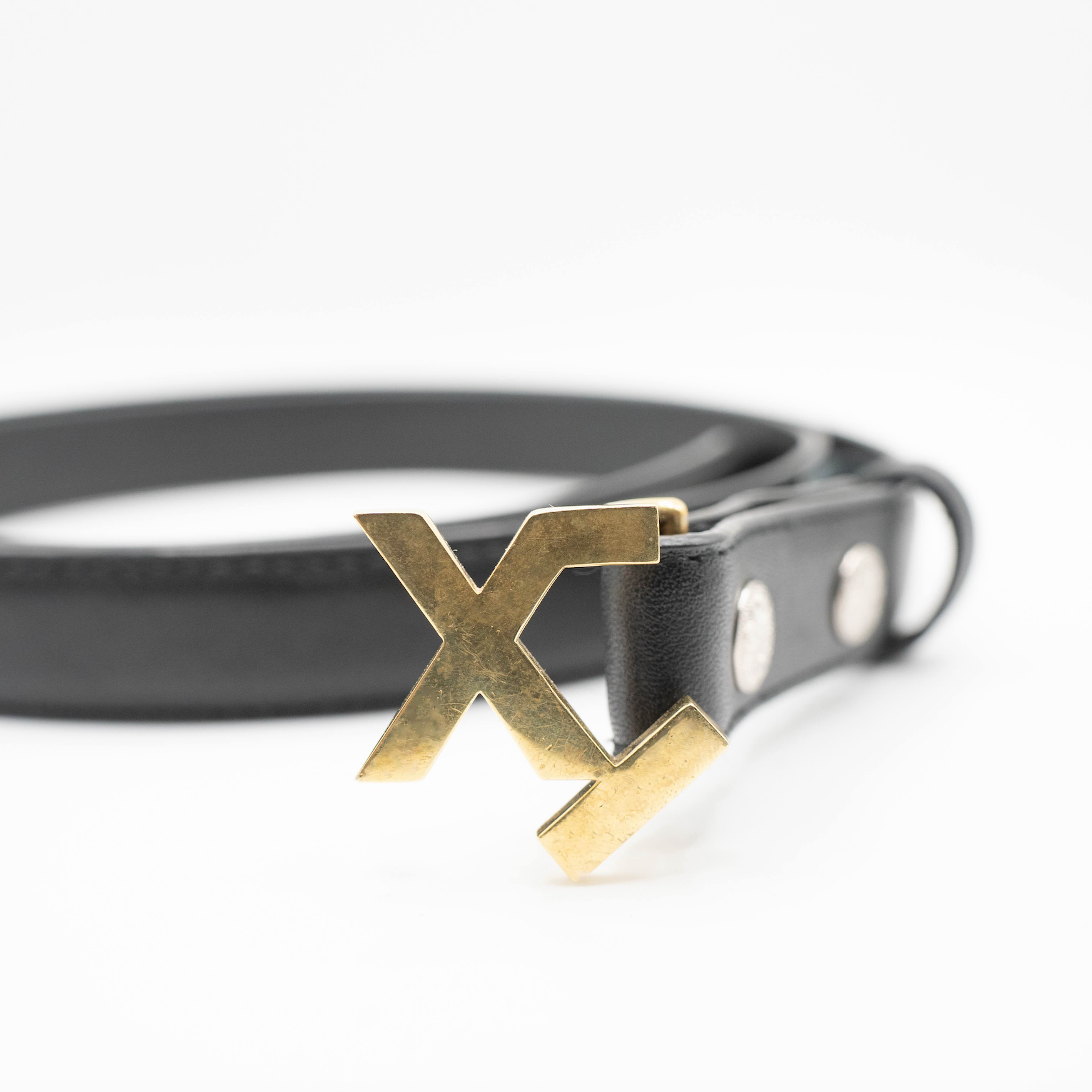 Black leather belt with a gold 'X' buckle on a white background
