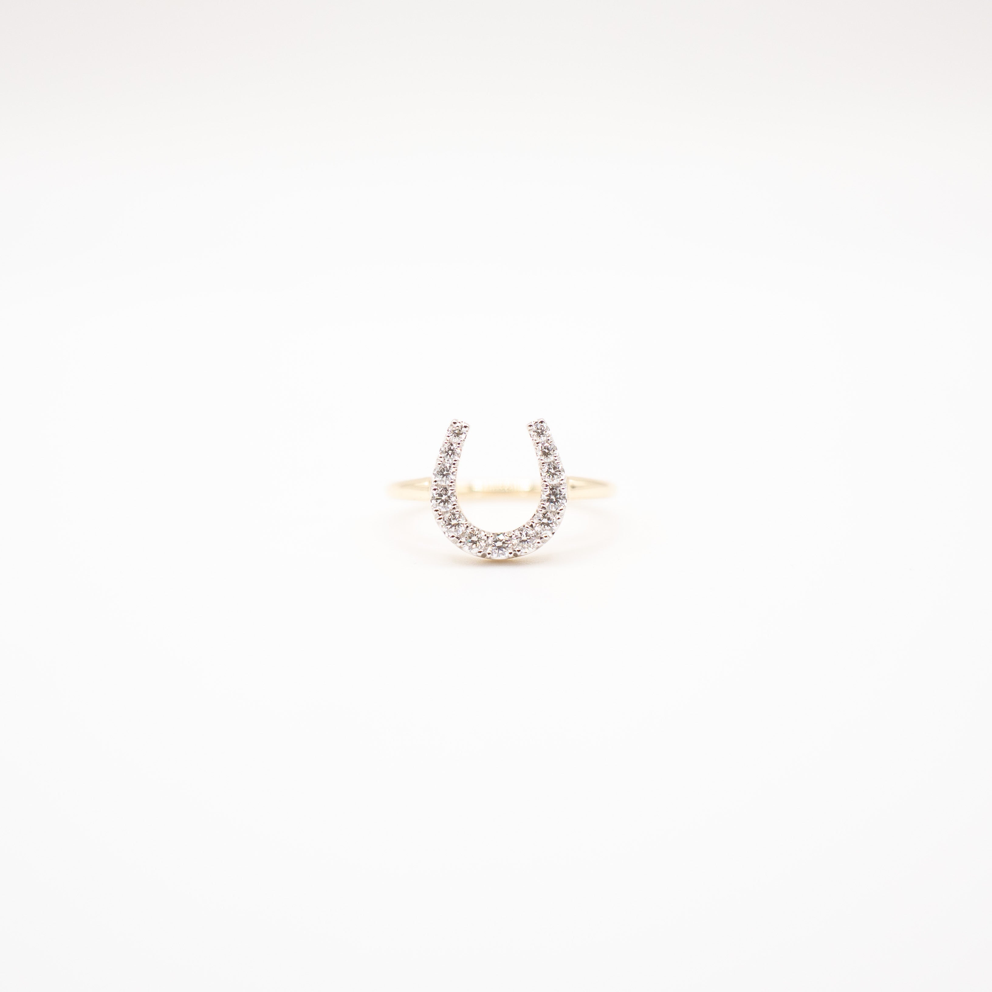Horseshoe-shaped ring with small diamonds on a white background