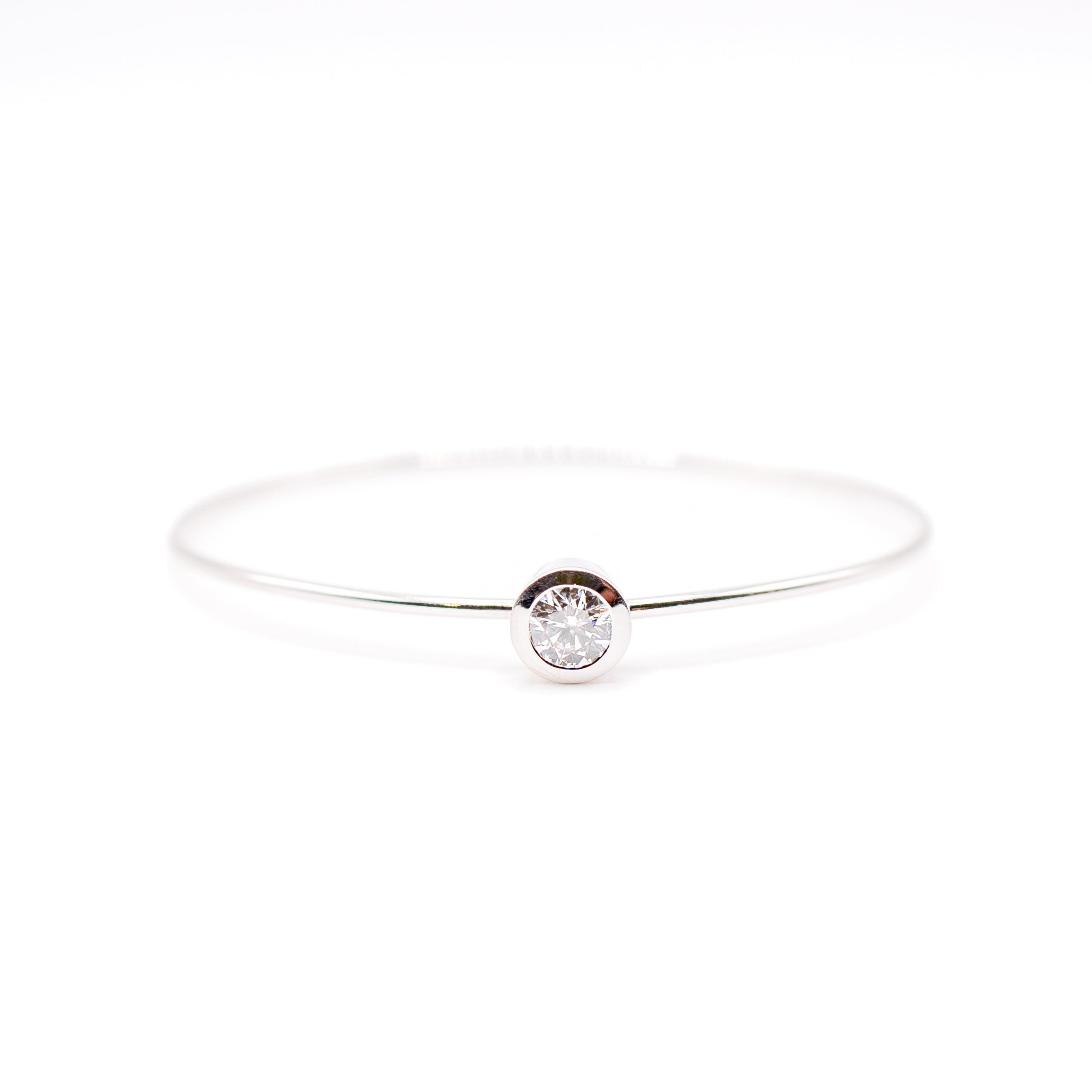 Delicate silver bracelet with a small round gemstone on a white background